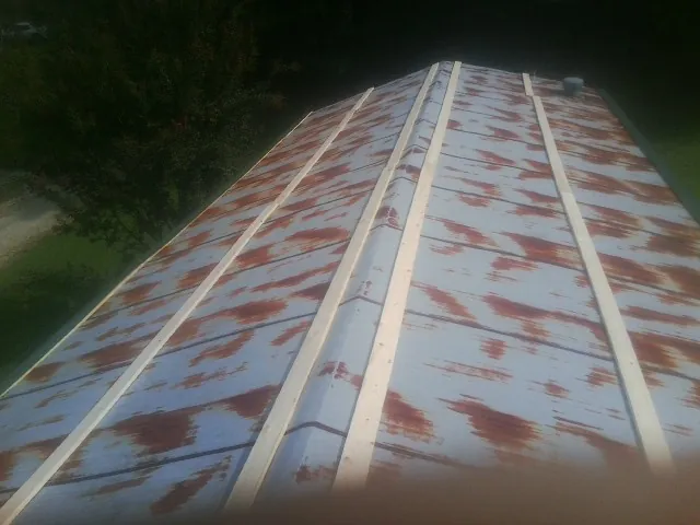 Rusted metal roof panels with new wood purlins before replacement — Storm Damage Roof Repair in Fountainville by Roofing Brothers