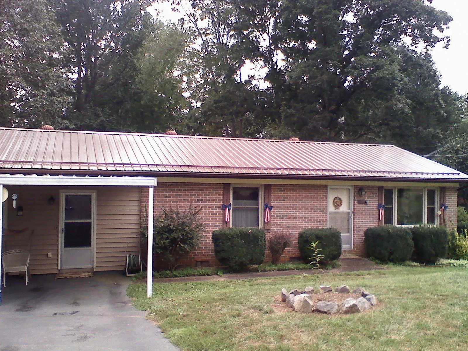 Bronze metal roof and carport on a brick ranch home — Roof Repair work by our crew in Fountainville